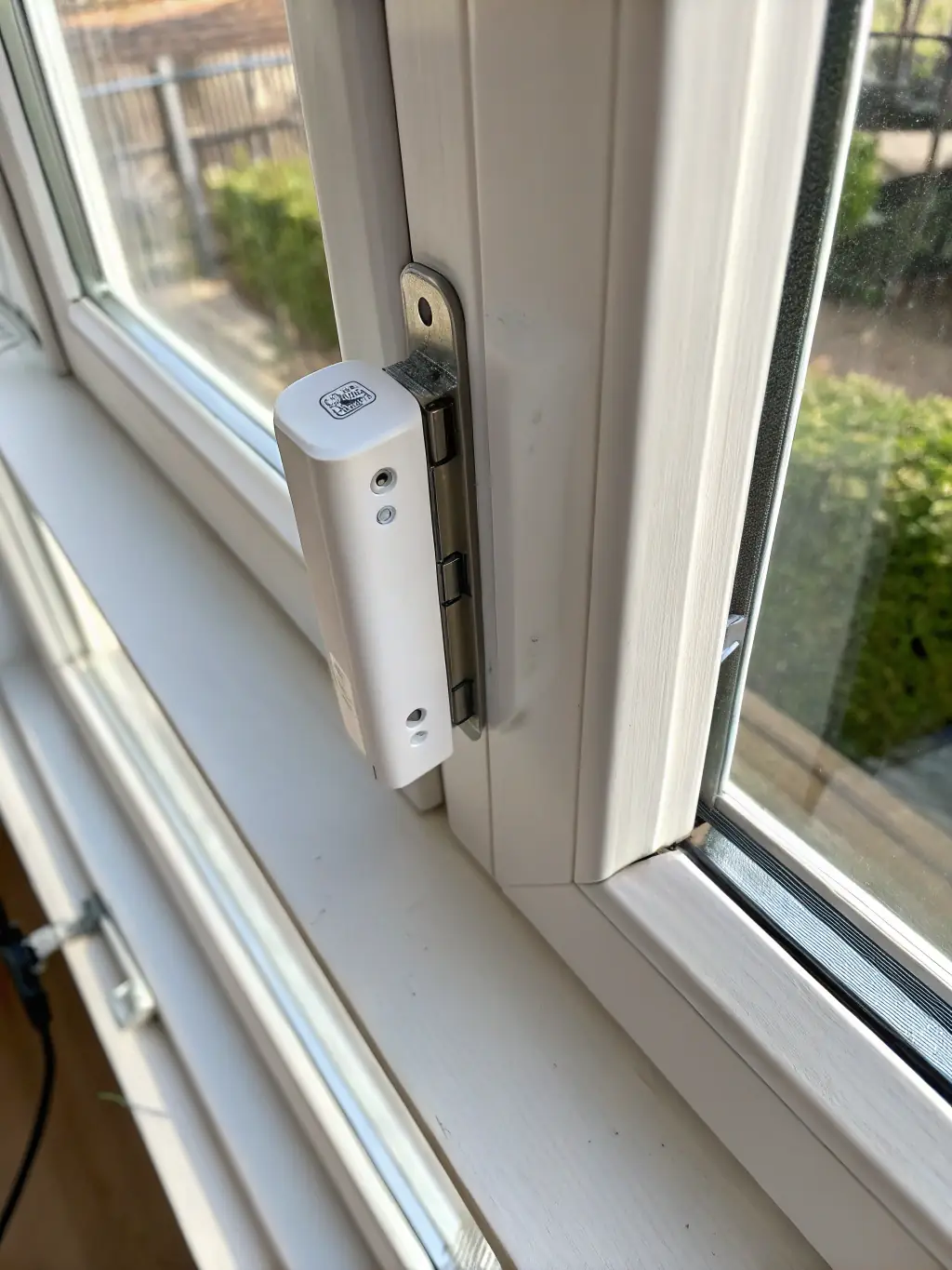 A close-up shot of a door/window sensor expertly installed on a window frame in a Montreal apartment, highlighting its compact size and secure placement.