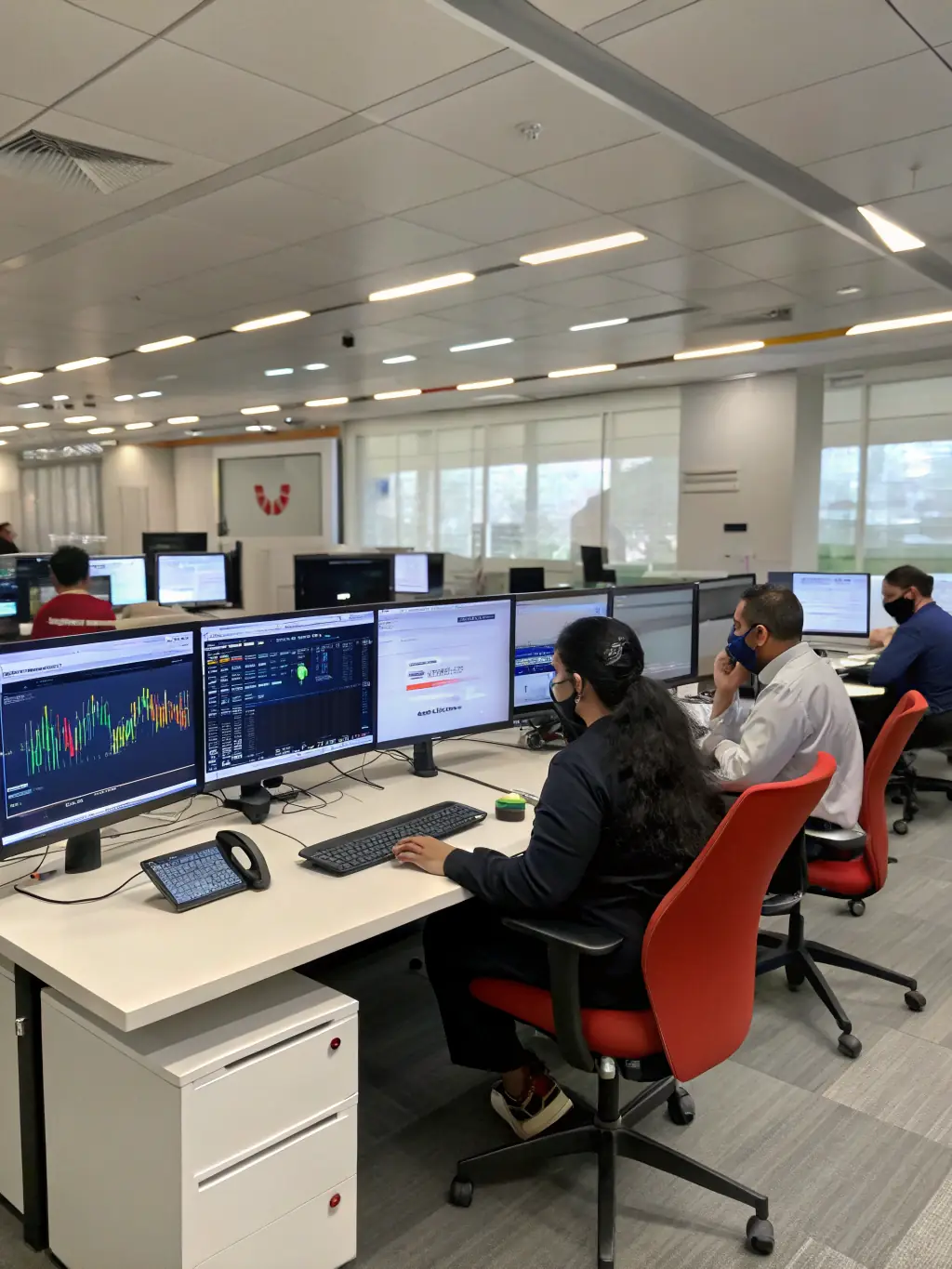 A brightly lit modern office space with several employees working at their desks, connected to a Fortexa-installed WiFi network, ensuring seamless connectivity and productivity.